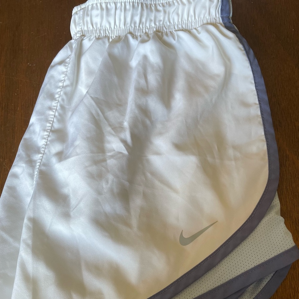 White nike running shorts with purple and light blue.